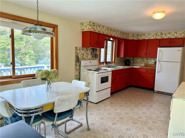 kitchen with white appliances, hanging light fixtures, tasteful backsplash, and sink