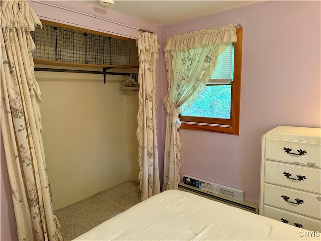 carpeted bedroom with a baseboard heating unit