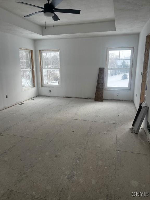 spare room featuring a tray ceiling and ceiling fan