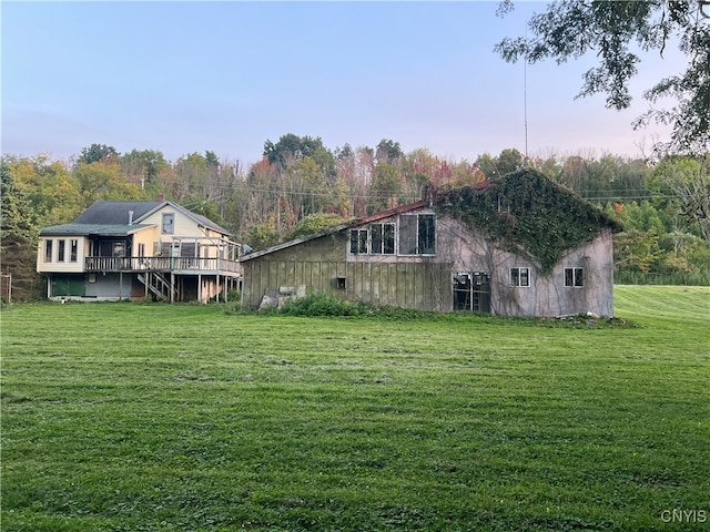 rear view of property featuring a lawn and a deck