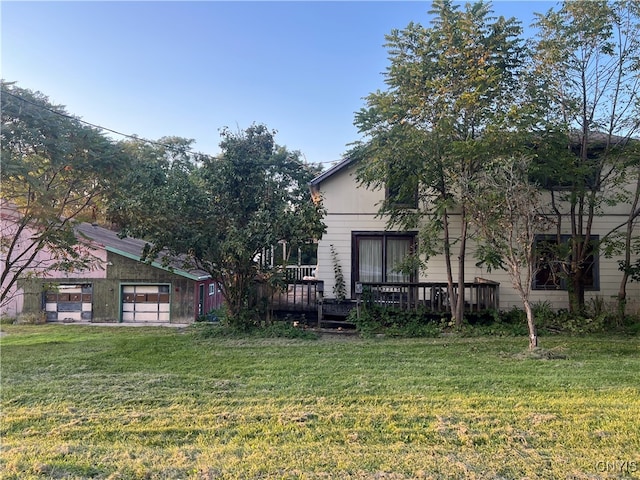 view of yard with a garage and a wooden deck