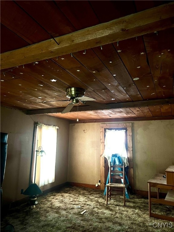 interior space with wood ceiling, ceiling fan, and carpet flooring