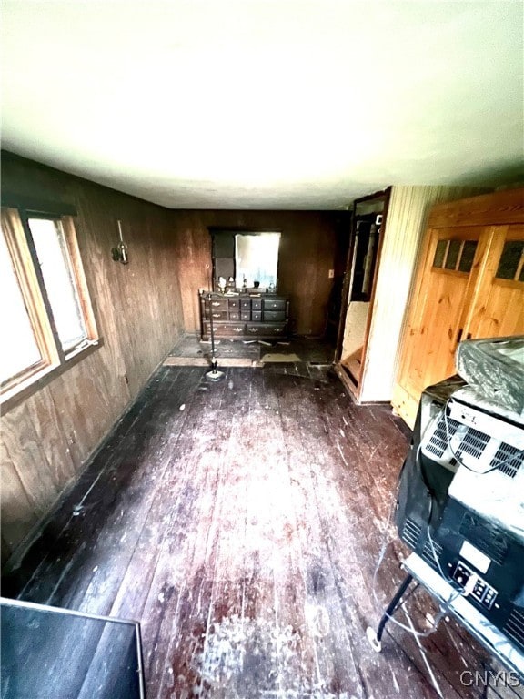 unfurnished living room featuring wood walls and dark hardwood / wood-style flooring