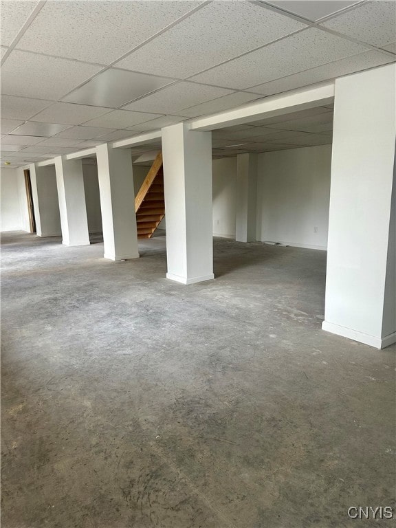 empty room featuring concrete flooring and a paneled ceiling