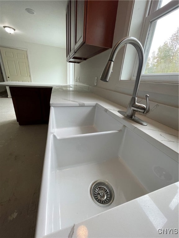 details featuring light stone countertops and sink