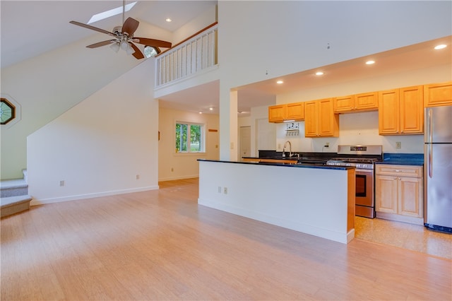 kitchen with stainless steel appliances, high vaulted ceiling, light brown cabinets, light hardwood / wood-style floors, and ceiling fan