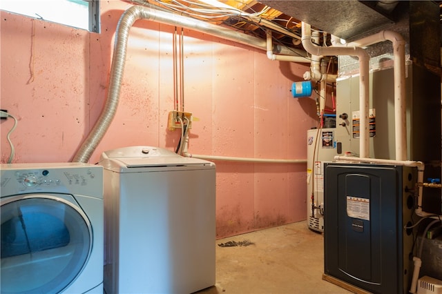 washroom with washing machine and clothes dryer, water heater, and heating unit