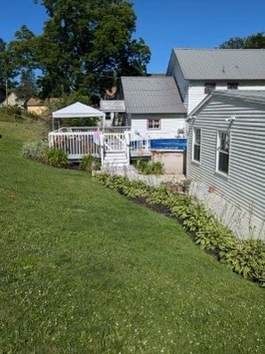 rear view of property with a deck and a lawn