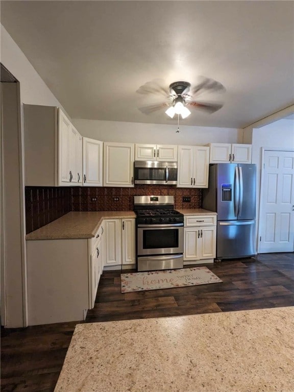 kitchen with ceiling fan, white cabinets, appliances with stainless steel finishes, dark hardwood / wood-style flooring, and decorative backsplash