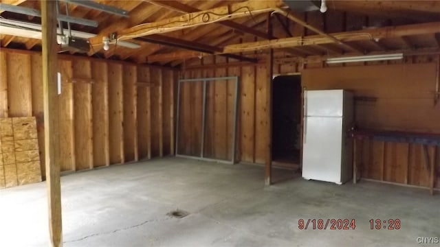 garage featuring white refrigerator and a garage door opener