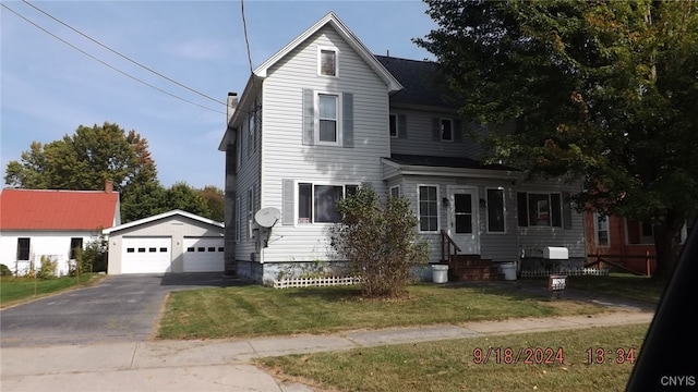 view of front of property featuring a garage, an outdoor structure, and a front lawn