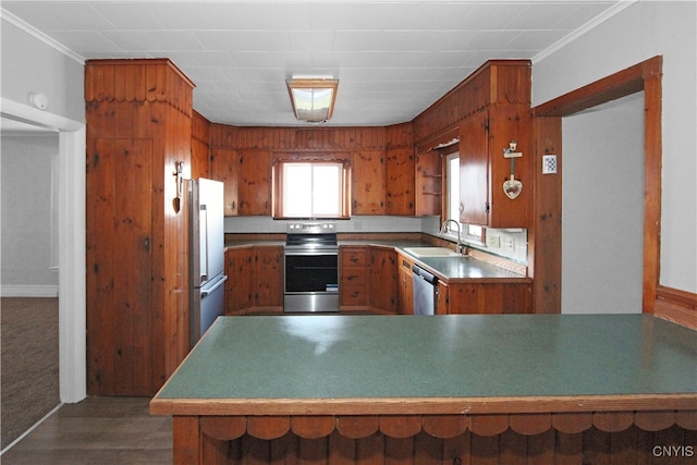 kitchen with sink, stainless steel appliances, dark hardwood / wood-style floors, kitchen peninsula, and crown molding