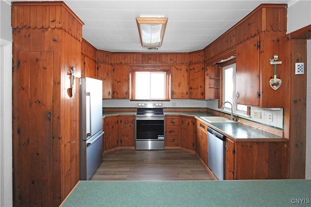 kitchen with appliances with stainless steel finishes, backsplash, dark wood-type flooring, and sink