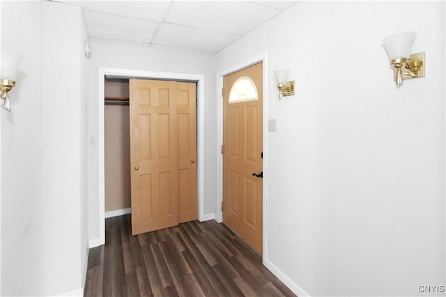 corridor with a paneled ceiling and dark hardwood / wood-style floors