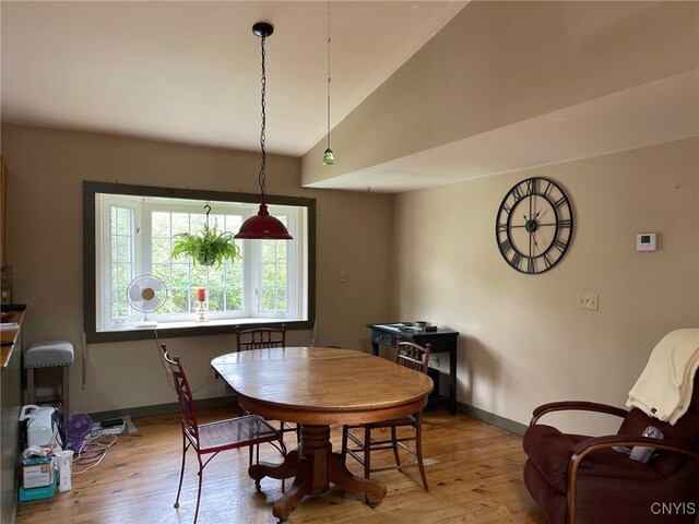 dining room featuring vaulted ceiling and light wood-type flooring