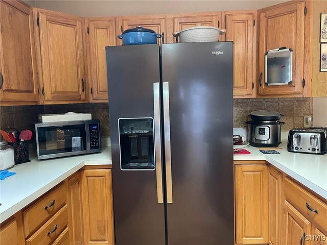 kitchen with backsplash and appliances with stainless steel finishes