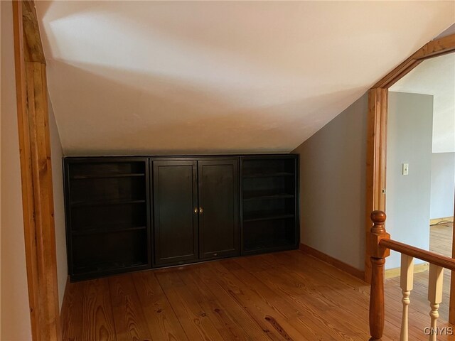 hall featuring hardwood / wood-style flooring and lofted ceiling