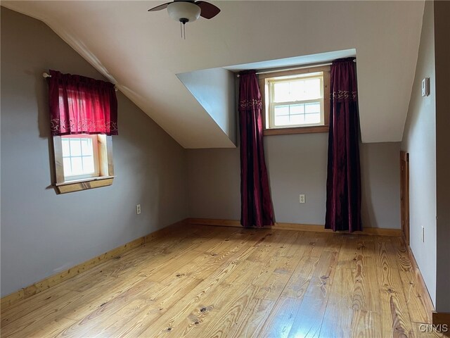 additional living space featuring ceiling fan, light wood-type flooring, and vaulted ceiling