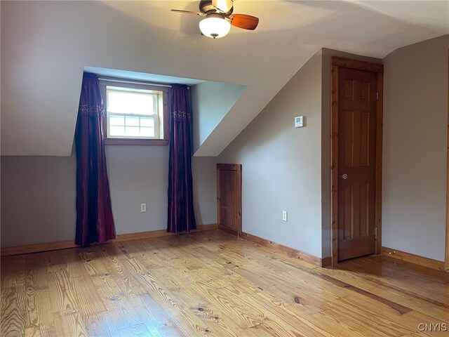 additional living space with light hardwood / wood-style flooring, lofted ceiling, and ceiling fan