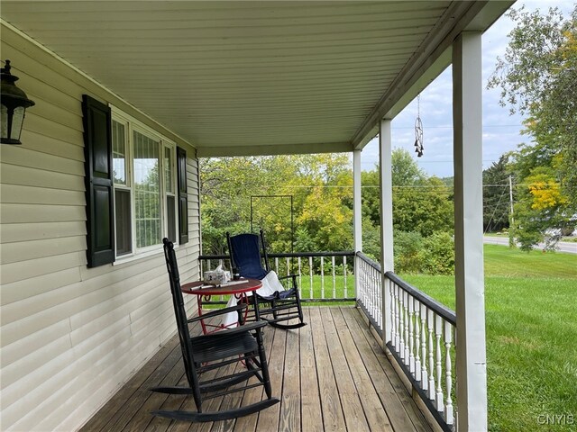 deck with covered porch and a yard