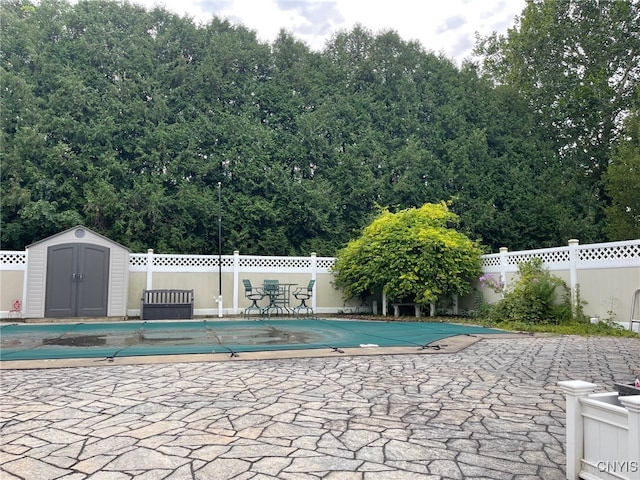 view of pool featuring a shed and a patio