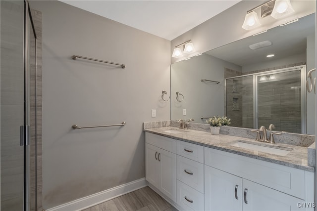 bathroom with hardwood / wood-style flooring, vanity, and a shower with shower door