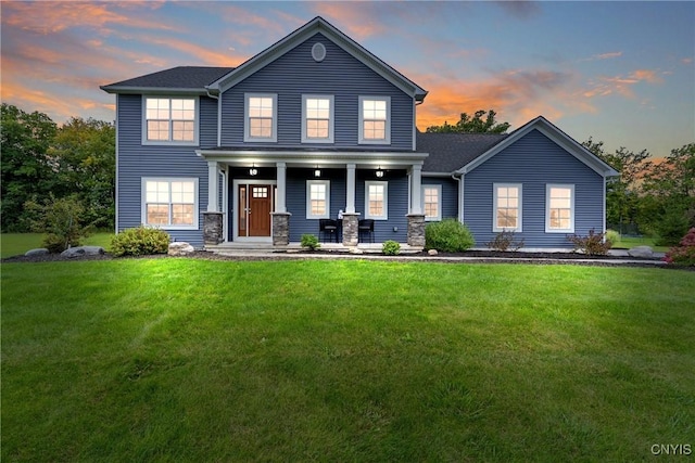 view of front of house featuring covered porch and a lawn