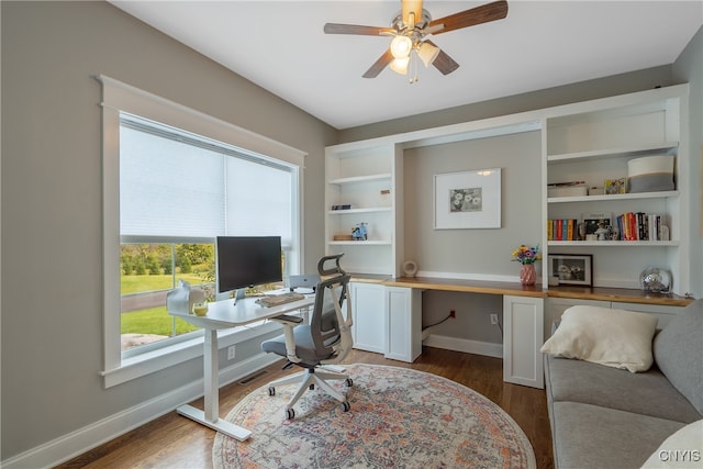 home office with ceiling fan and dark hardwood / wood-style floors