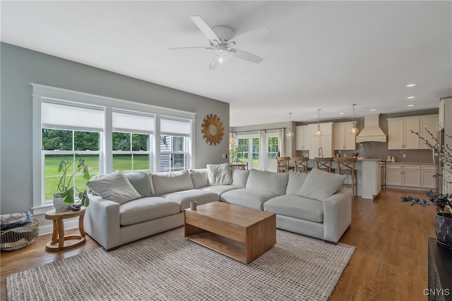 living room featuring ceiling fan and light wood-type flooring