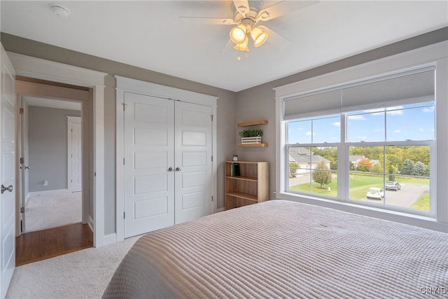 carpeted bedroom featuring ceiling fan and a closet