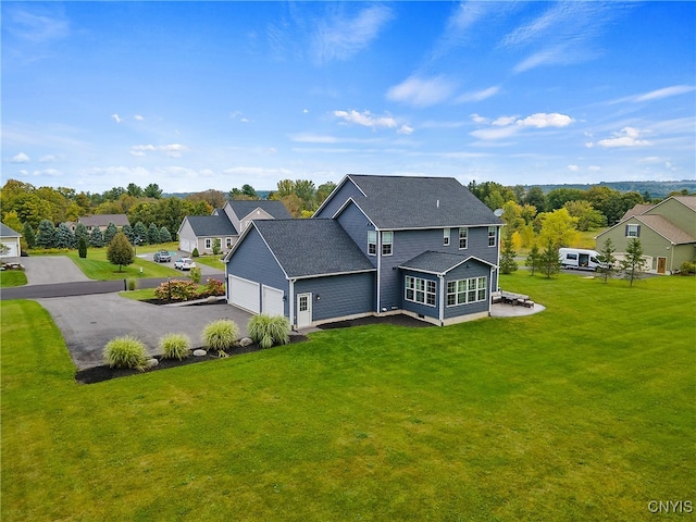 back of house with a lawn and a garage