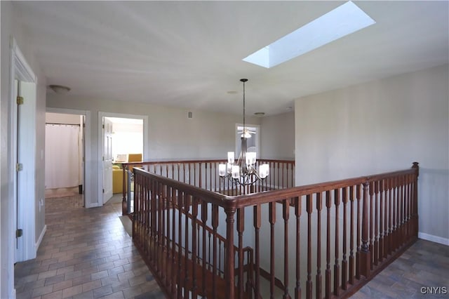 hall featuring a skylight and a chandelier