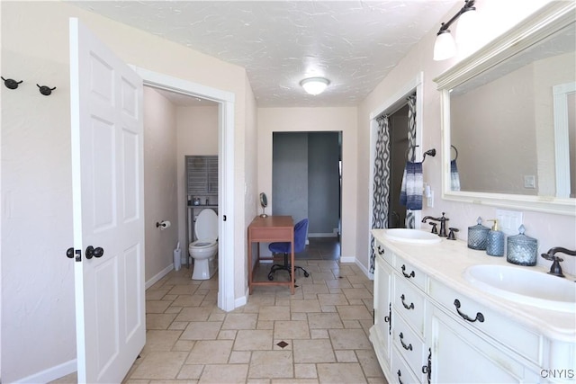 bathroom with vanity, a textured ceiling, and toilet