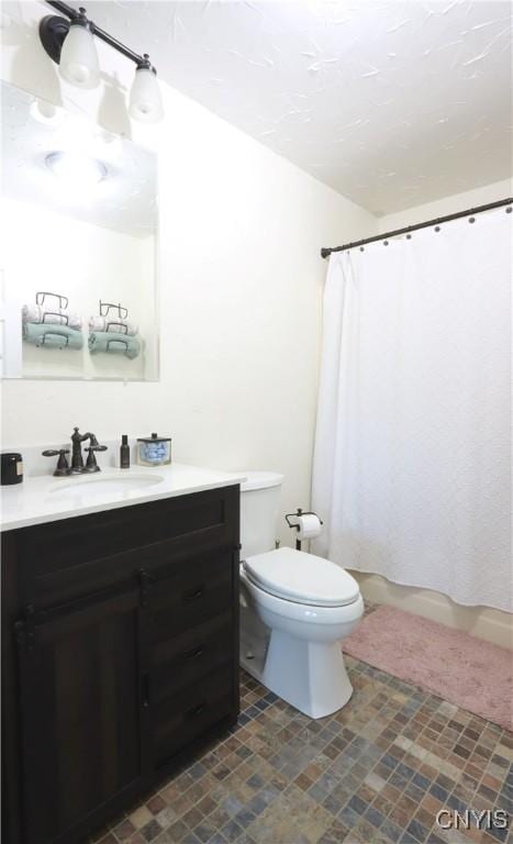 bathroom with vanity, curtained shower, and toilet