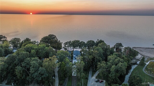 aerial view at dusk featuring a water view