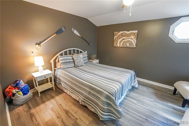 bedroom with wood-type flooring and vaulted ceiling