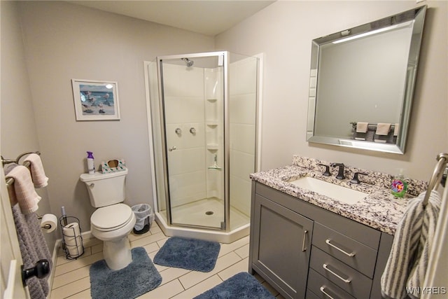 bathroom featuring vanity, toilet, tile patterned floors, and an enclosed shower