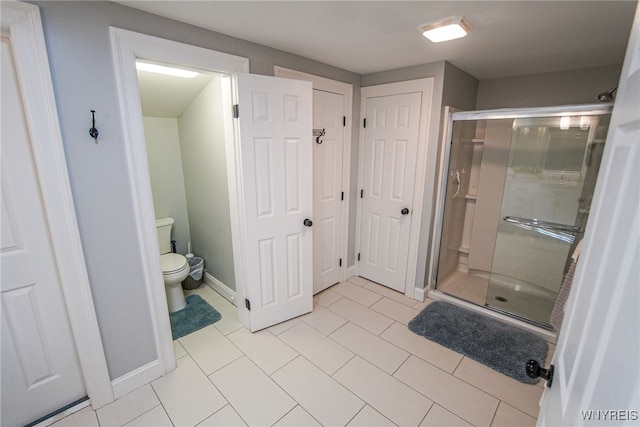 bathroom featuring walk in shower, toilet, and tile patterned floors