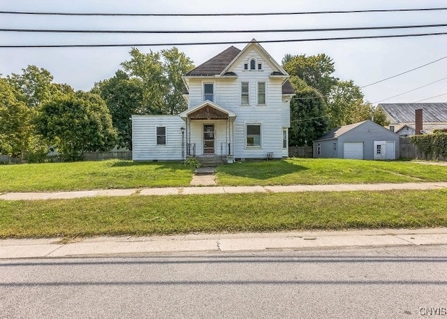 view of front facade with an outbuilding, a garage, and a front lawn