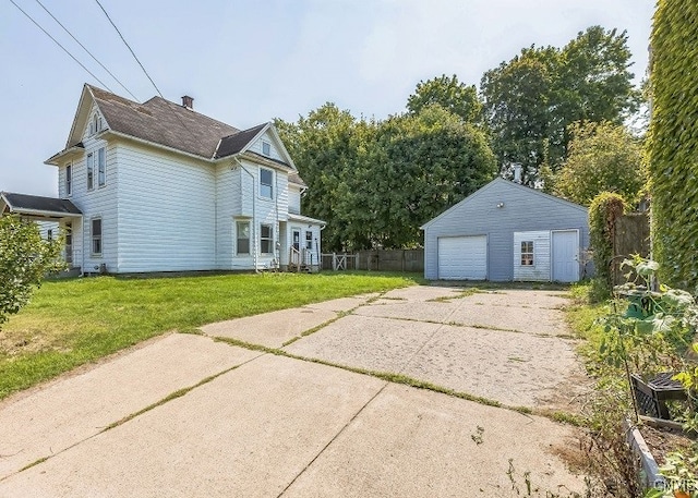 exterior space with a garage, a yard, and an outbuilding