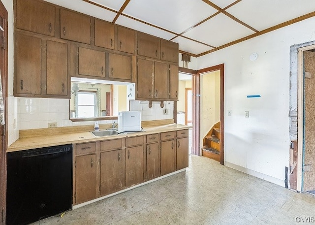 kitchen featuring black dishwasher, sink, and tasteful backsplash