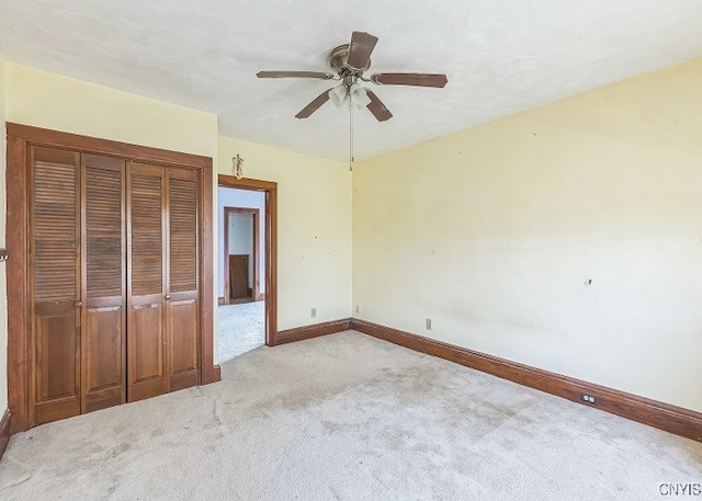 unfurnished bedroom featuring light carpet, a closet, and ceiling fan