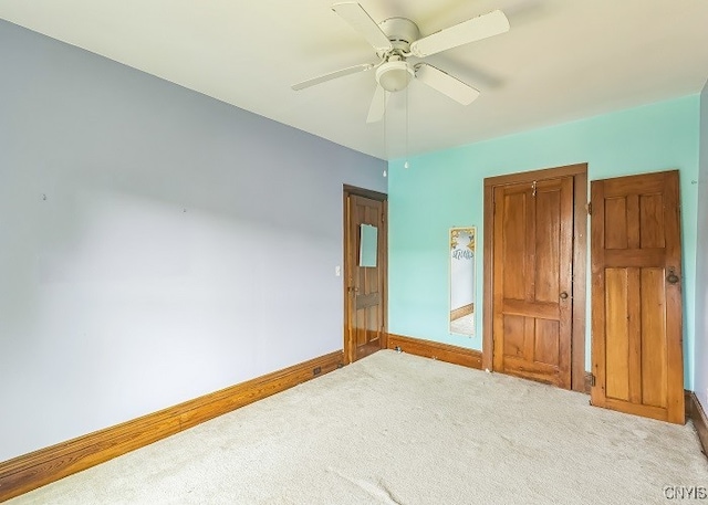 unfurnished bedroom with ceiling fan and light carpet