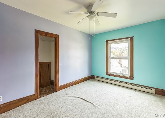 unfurnished room featuring a baseboard heating unit, ceiling fan, and carpet flooring