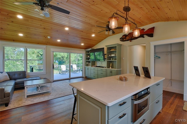 kitchen featuring vaulted ceiling, dark wood-type flooring, a breakfast bar, wooden ceiling, and ceiling fan