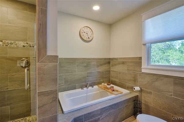 bathroom featuring shower with separate bathtub