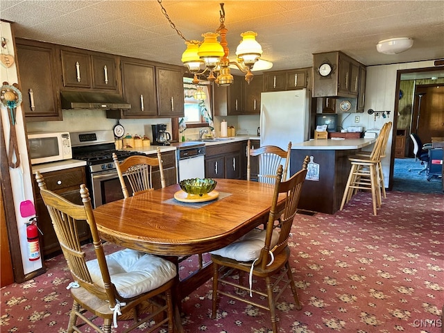 carpeted dining space featuring a notable chandelier, a textured ceiling, and sink