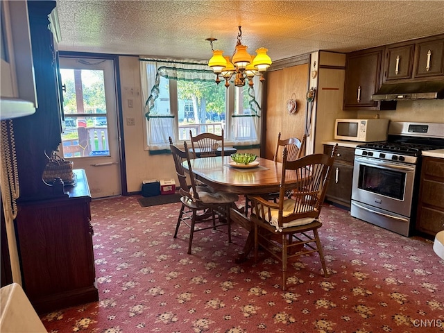 carpeted dining area with a notable chandelier and a textured ceiling