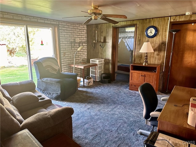 carpeted living room with wood walls and ceiling fan