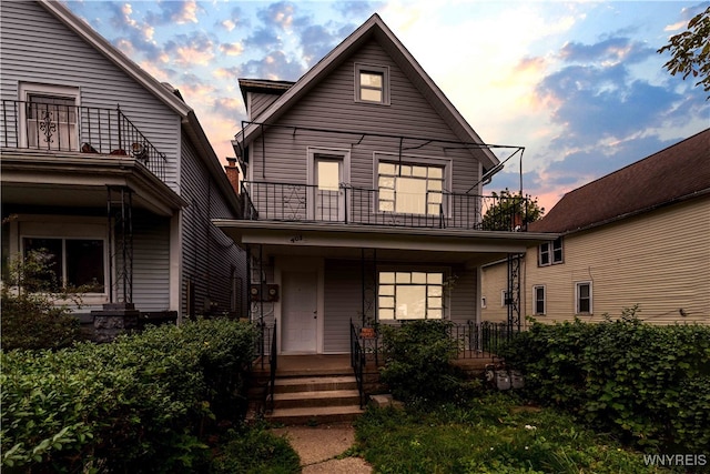 view of front of house with a balcony and covered porch